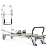 Elina Pilates Mentor Reformer mit Tower aus Aluminium – Schrägansicht mit Polstern in Eukalyptus, freigestellt vor weißem Hintergrund