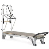 Elina Pilates Mentor Reformer mit Tower aus Aluminium – Schrägansicht mit Polstern in Mokka, freigestellt vor weißem Hintergrund