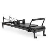 Elina Pilates Nubium Black Edition Reformer aus schwarzem Aluminium in Schrägansicht mit Schulterstützen und Fußstange