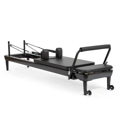 Elina Pilates Nubium Black Edition Reformer aus schwarzem Aluminium in Schrägansicht mit Schulterstützen und Fußstange