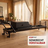 Elina Pilates Nubium Black Edition Reformer aus schwarzem Aluminium in einem hellen Pilates-Studio mit Holz und Leinen