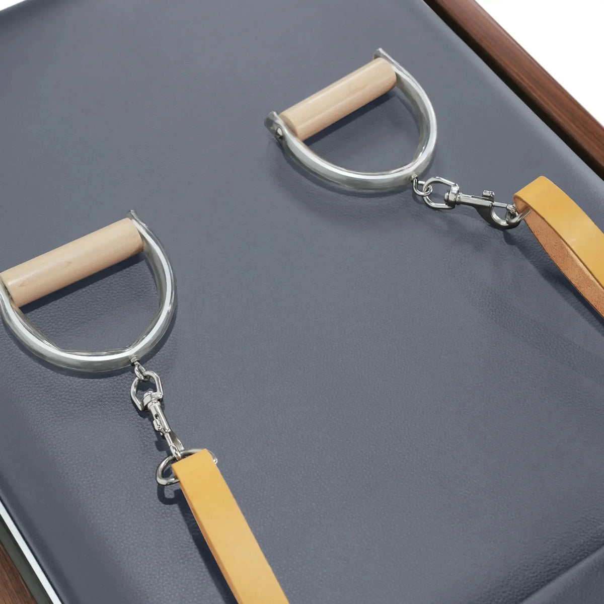 Elina Pilates Reformer Cadillac Klassisch Dunkles Holz – Detail der Holzgriffe mit Karabinern auf grauem Polster