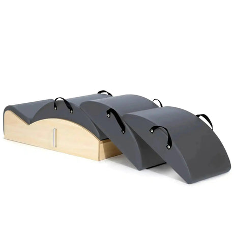 Elina Pilates Spine Corrector 3 in 1 in Grau, Schrägansicht mit Holzsockel und drei Polsteraufsätzen