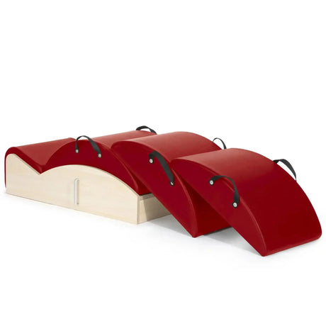Elina Pilates Spine Corrector 3 in 1 in Rot, Schrägansicht mit Holzsockel und drei gestapelten Polsteraufsätzen