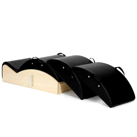 Elina Pilates Spine Corrector 3 in 1 in Schwarz, Schrägansicht mit Holzsockel und drei Polsteraufsätzen
