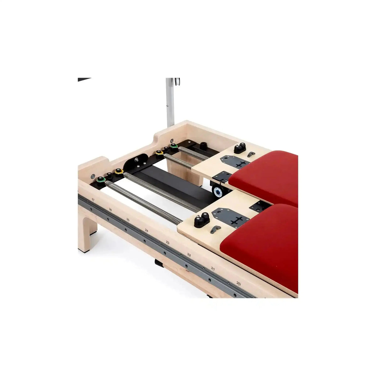 Elina Pilates Twin Reformer aus Ahornholz, Detail des Rahmens mit Schienen und roten Polstern von oben