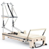 Elina Pilates Twin Reformer aus Ahornholz mit Polstern in Elfenbein, Seitenansicht mit Turm auf Weiß