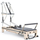 Elina Pilates Twin Reformer aus Ahornholz mit grauen Polstern, Seitenansicht mit Turm auf weißem Hintergrund