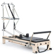 Elina Pilates Twin Reformer aus Ahornholz mit schwarzen Polstern, Seitenansicht mit Turm und Fußstange