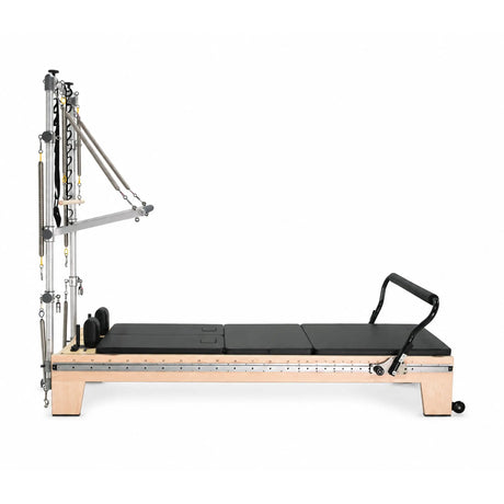 Elina Pilates Twin Reformer with black padding, side view showing the tower and footrest on a white background