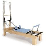 Elina Pilates Wooden Reformer Fisio mit Tower, Schrägansicht mit Polster in Ozeanblau und Holzrahmen