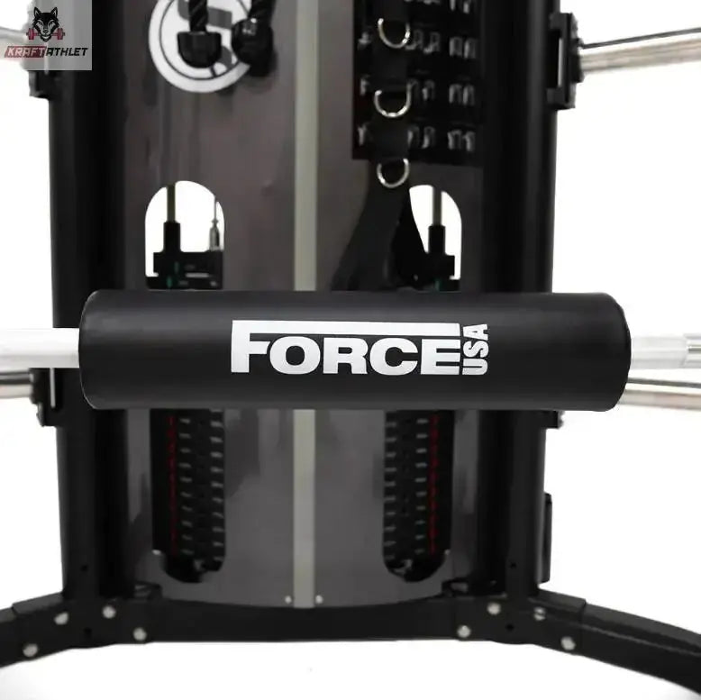 Force USA Barbell Pad auf einer Langhantel vor einem Kraftturm montiert, Frontansicht im Einsatz