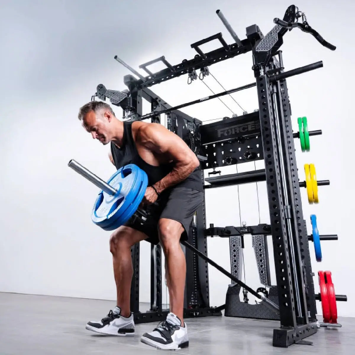 Force USA C20 All-In-One Trainer – Mann rudert mit Landmine und Hantelscheibe
