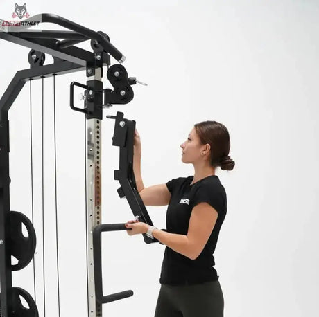 Force USA G6 Jammer Arms, Frau hängt einen Arm seitlich an den Rahmen des Trainingsgeräts ein