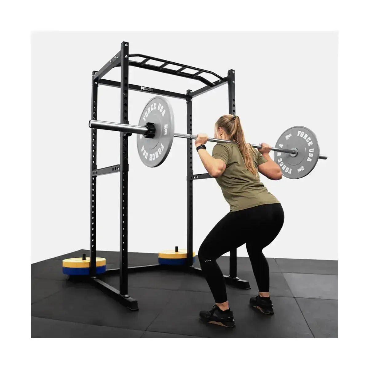 Force USA PT V2 Power Rack + Lat Attachment, Frau beim Kniebeugen mit beladener Langhantel