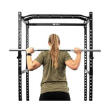 Force USA PT V2 Power Rack + Lat Attachment, Rückansicht einer Frau mit Langhantel im Rack
