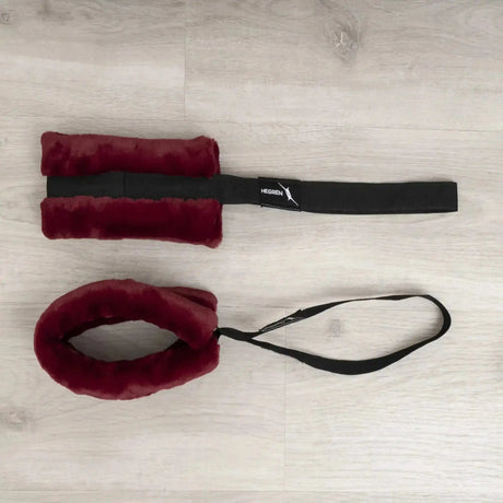 Hegren Cadillac Fur Loops in Bordeaux, Hand- und Fußschlaufe mit schwarzem Gurt auf Holzboden, Draufsicht