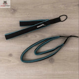 Hegren Double Loop Straps, Schlaufe mit Seil in Schwarz-Türkis auf Holzboden