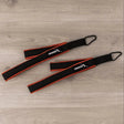 Hegren Double Loop Straps, Paar Schlaufen in Schwarz-Rot auf Holzboden