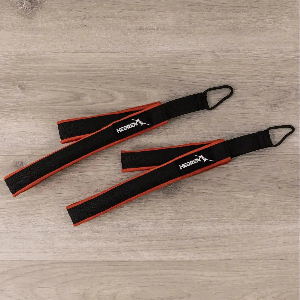 Hegren Double Loop Straps, Paar Schlaufen in Schwarz-Rot auf Holzboden