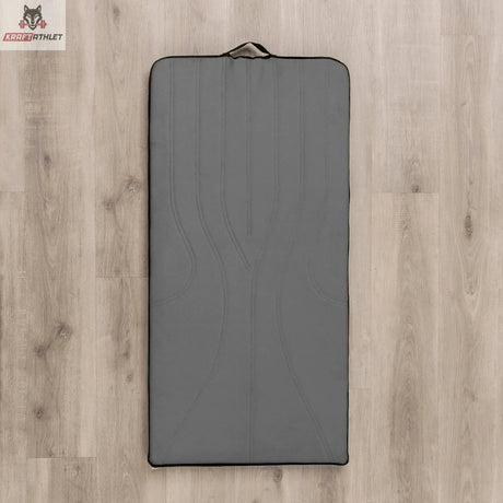 Hegren High Density Pilates-Matte in Grau, Draufsicht auf Holzboden mit Tragegriff am Kopfende