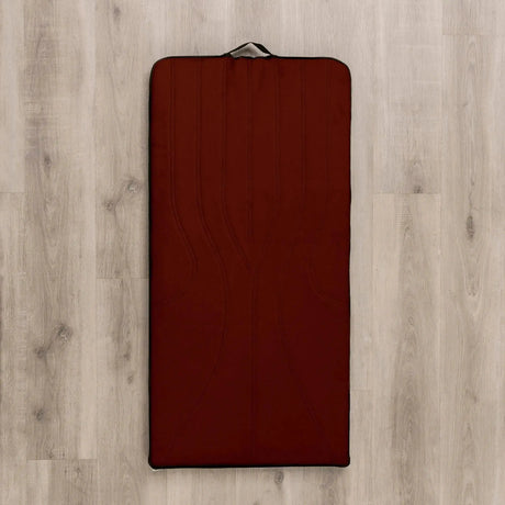Hegren High Density Pilates-Matte in Orangebraun, Draufsicht auf hellem Holzboden mit Tragegriff