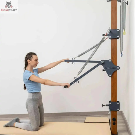 Hegren High Density Pilates-Matte, Frau kniet auf der Matte und zieht die Griffe der Wand-Pilates-Station nach vorn
