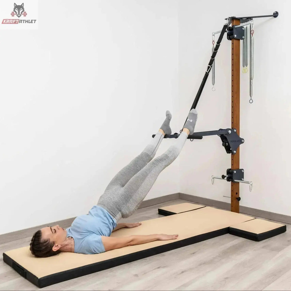 Hegren High Density Pilates-Matte mit modularen Kissen, Frau in Rückenlage mit Beinen in den Schlaufen der Wandstation