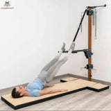 Hegren High Density Pilates-Matte mit modularen Kissen, Frau in Rückenlage mit Beinen in den Schlaufen der Wandstation