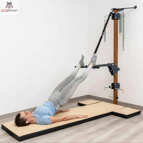 Hegren High Density Pilates-Matte mit modularen Kissen, Frau in Rückenlage mit Beinen in den Schlaufen der Wandstation