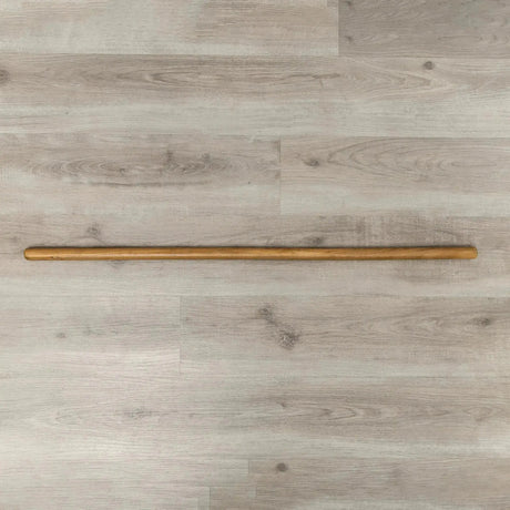 Hegren Pilates Wooden Stick 1,10 m aus Eiche, ganzer Stab liegend auf hellem Holzboden