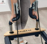 Hegren TALMA 62 Reformer mit Box und Jumpboard im Detail: Hände an den Griffen der Fußstange mit TALMA 62 Gravur
