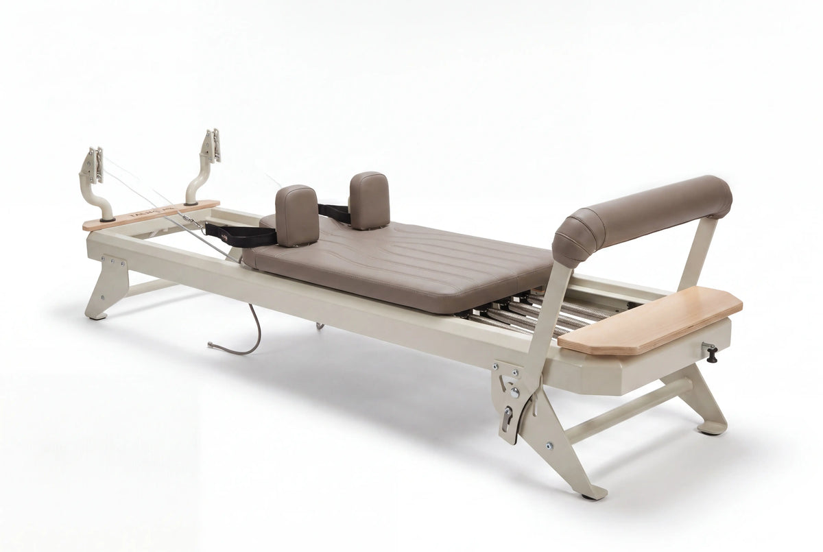 Hegren TALMA 62 Reformer mit Box und Jumpboard in Schrägansicht mit hellem Rahmen und taupefarbenen Polstern freigestellt
