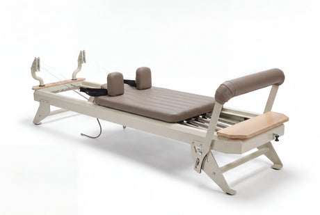 Hegren TALMA 62 Reformer mit Box und Jumpboard in Schrägansicht mit hellem Rahmen und taupefarbenen Polstern freigestellt