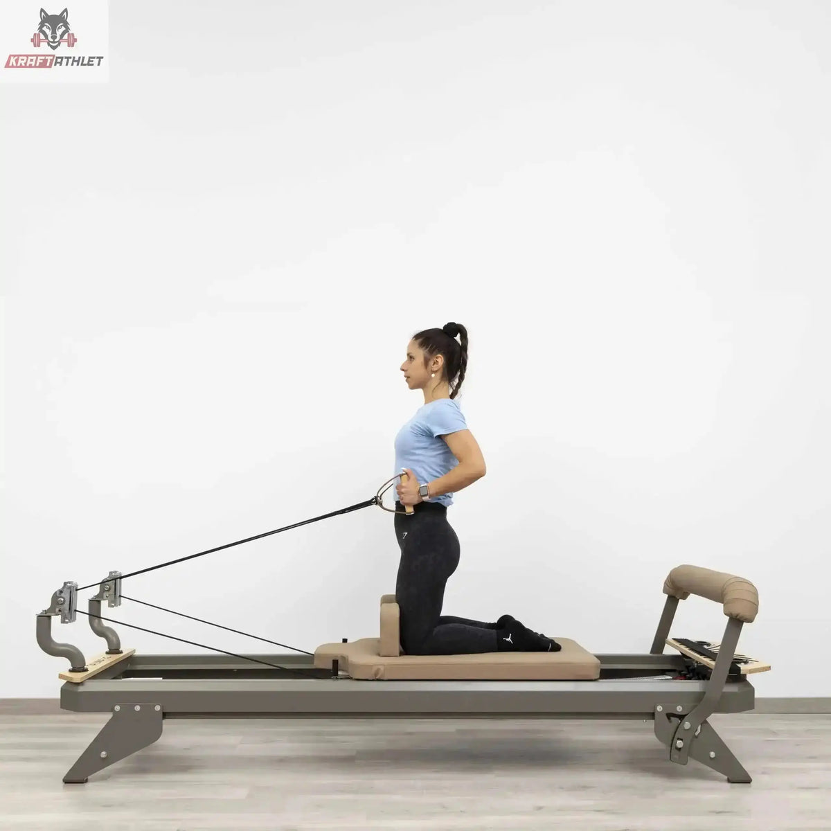 Hegren TALMA 62 Reformer mit Box und Jumpboard mit Frau im Kniestand beim Seilzug-Training in Seitenansicht