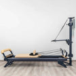 Hegren TALMA 62CT+ Reformer mit Tower, Seitenansicht mit Tower-Arm und Seilen im hellen Studio