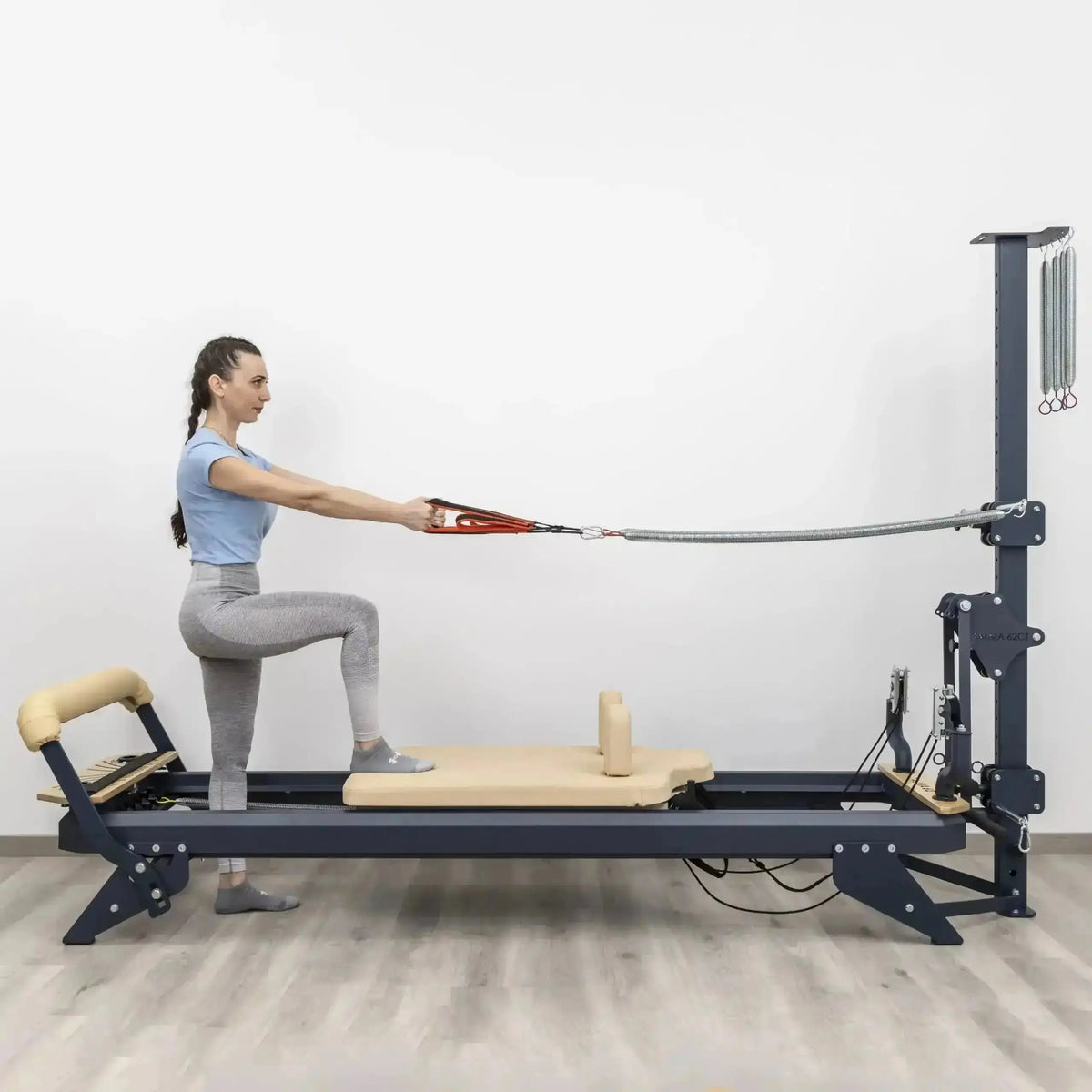 Hegren TALMA 62CT+ Reformer mit Tower, Frau im Ausfallschritt auf dem Schlitten mit Seilzug