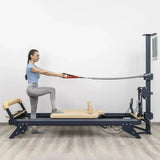 Hegren TALMA 62CT+ Reformer mit Tower, Frau im Ausfallschritt auf dem Schlitten mit Seilzug