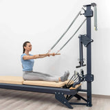 Hegren TALMA 62CT+ Reformer mit Tower, Frau trainiert im Sitzen mit der Stange am Tower