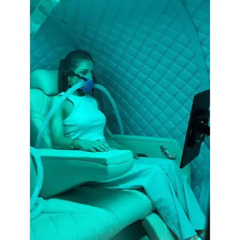 ProReset Atlantis Hyperbarkammer – Innenraum mit Person im Liegesitz mit Maske bei türkisem Licht