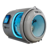 ProReset Atlantis Hyperbarkammer – Schrägansicht in Grau mit blau beleuchteter Tür und Tablet