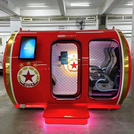 ProReset Mediterranean Hyperbarkammer in Rot mit Vereinswappen, offenen Türen und Tablet in einer Halle