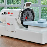 ProReset VacuPro Vakuum-Wellnesssystem – Schrägansicht mit hellblauer Liege vor einer Fensterfront