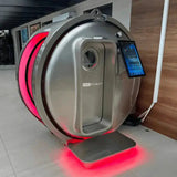 ProReset Zeugma Sitz-Hyperbarkammer in Silber mit roter Beleuchtung und Tablet in einem Raum