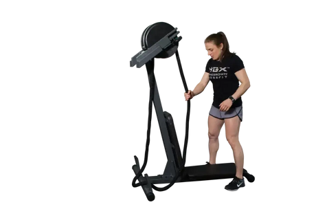 Ropeflex RX2300 Dual-Position-Seiltrainer, Frau steht am Gerät und greift das Seil vor schwarzem Hintergrund