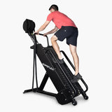 Ropeflex RX4400 Kletter-Seiltrainer, Schrägansicht von vorn mit Mann im roten Shirt am Seil auf Weiß