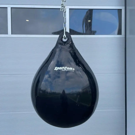 SportCom AquaStrike Wassersandsack Schwarz, hängend an der Kette vor einem Garagentor