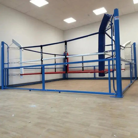 SportCom Beweglicher Boxring – mit blauem Rahmen in heller Halle, Schrägansicht