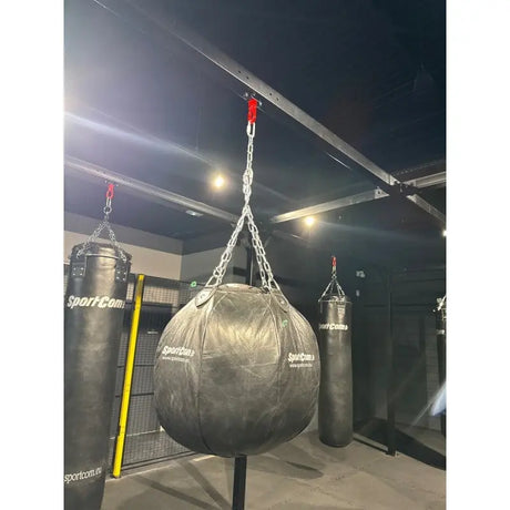 SportCom Birnenförmiger Uppercut-Sandsack Echtleder zwischen länglichen Sandsäcken in einer Boxhalle