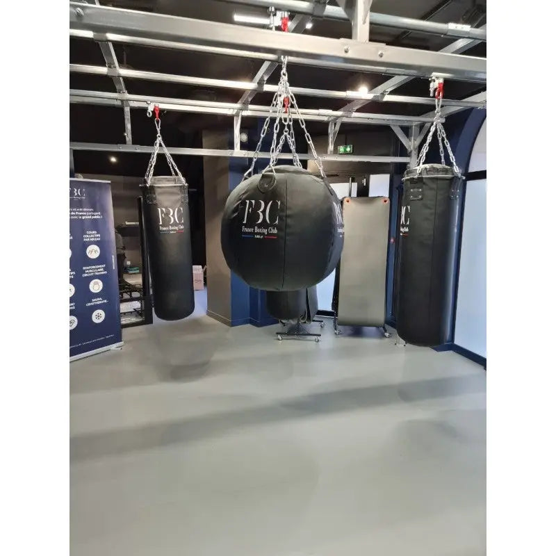 SportCom Birnenförmiger Uppercut-Sandsack Kunstleder mit Logo-Druck zwischen zwei Säcken am Gestell